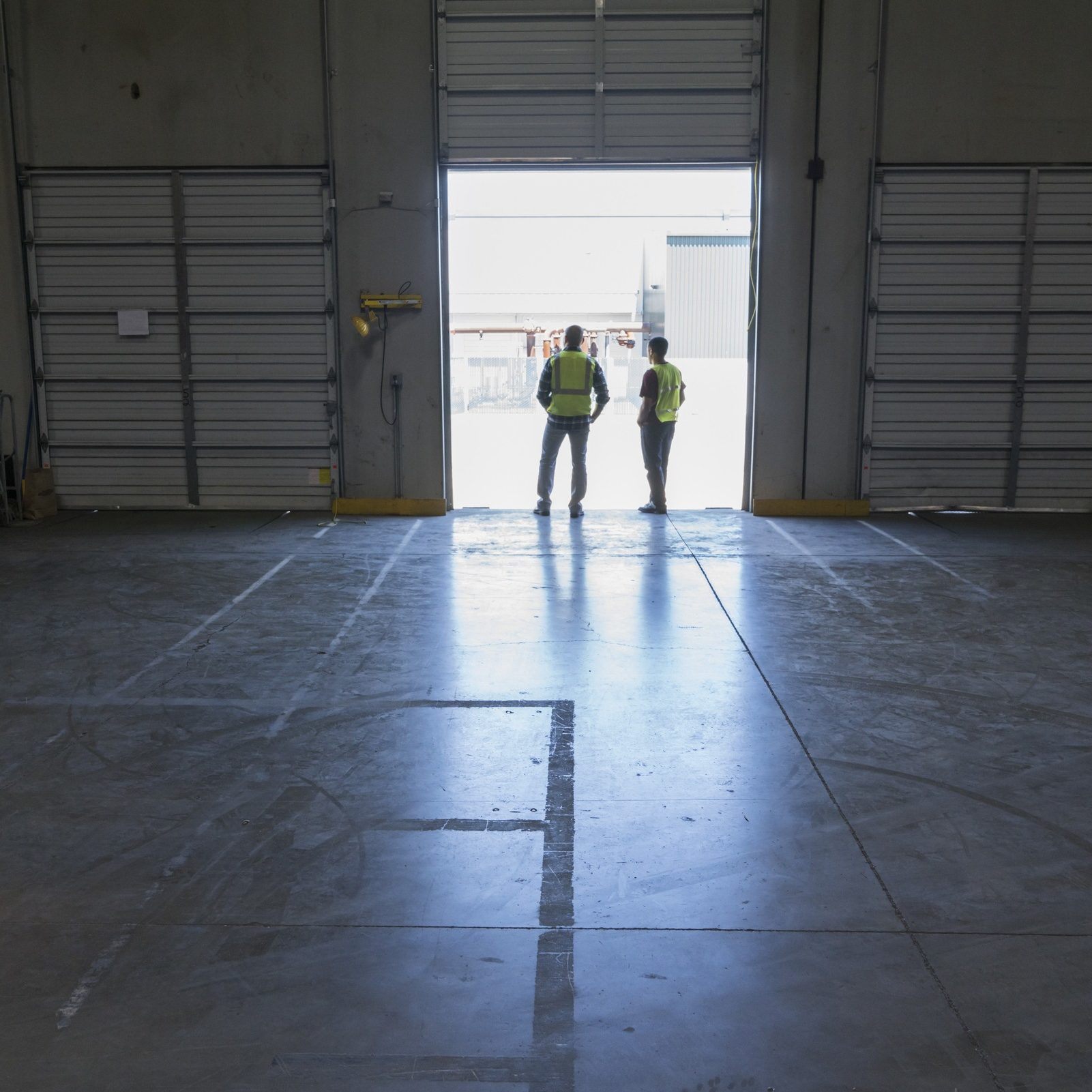 Warehouse loading dock door and warehouse workers waiting for product to arrive.